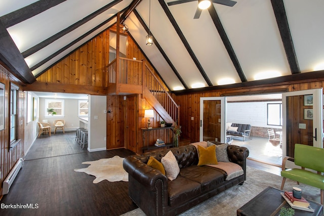 living room featuring dark hardwood / wood-style flooring, beam ceiling, wood walls, and baseboard heating