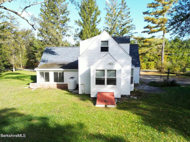 back of property featuring a lawn