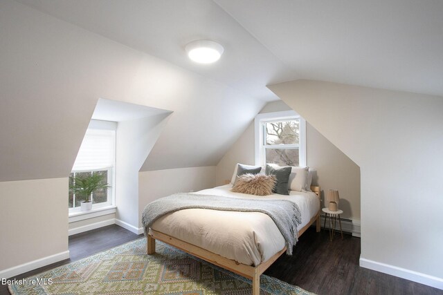 bedroom featuring baseboard heating, dark hardwood / wood-style flooring, and vaulted ceiling