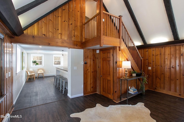 staircase featuring a baseboard heating unit, high vaulted ceiling, wood-type flooring, beamed ceiling, and wood walls