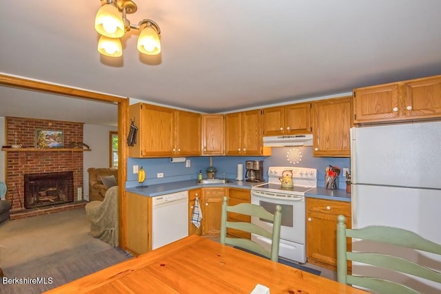 49 Bryant Rd, Otis, MA 01253 - kitchen featuring white appliances, under cabinet range hood, a brick fireplace, and brown cabinetry