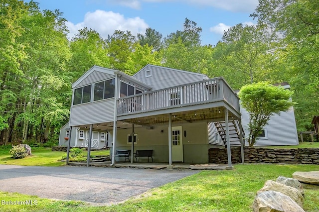 49 Bryant Rd, Otis, MA 01253 - back of property featuring a patio area, a wooden deck, a sunroom, driveway, and a lawn