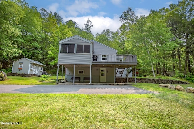 49 Bryant Rd, Otis, MA 01253 - back of property featuring a wooden deck, stairs, a yard, a sunroom, and asphalt driveway