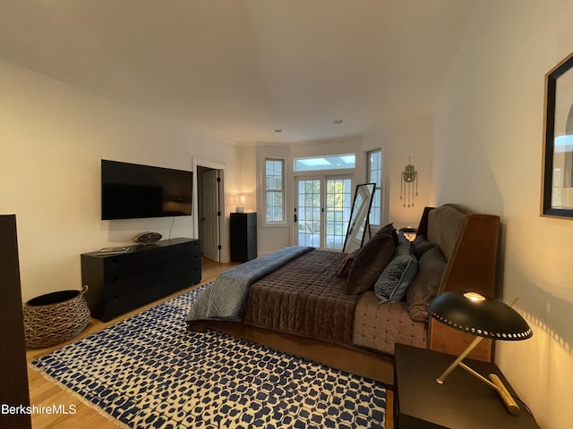 bedroom with french doors and hardwood / wood-style flooring