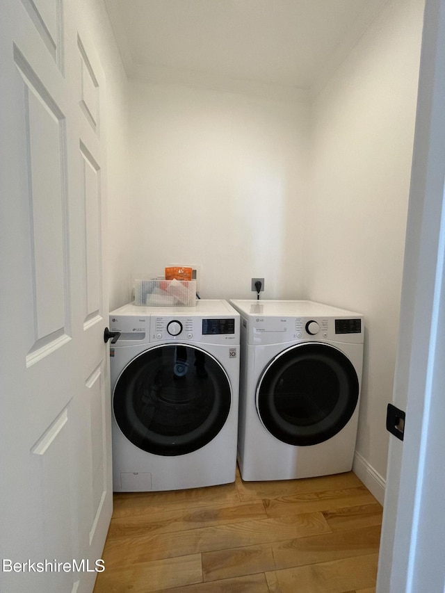 laundry area featuring light wood-type flooring and washing machine and clothes dryer