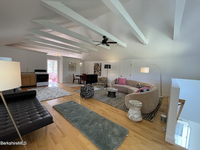 living room with lofted ceiling with beams, ceiling fan, wood-type flooring, and sink