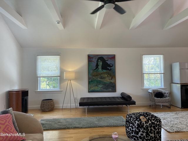 living room with plenty of natural light, lofted ceiling with beams, and wood-type flooring