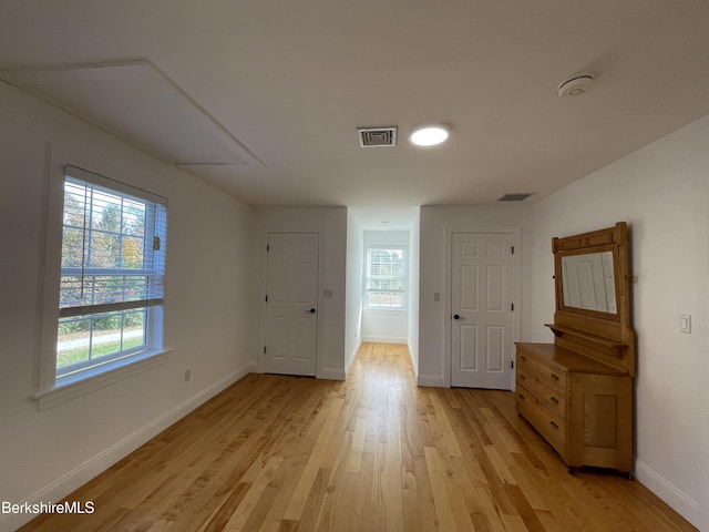 spare room featuring light hardwood / wood-style flooring and a healthy amount of sunlight