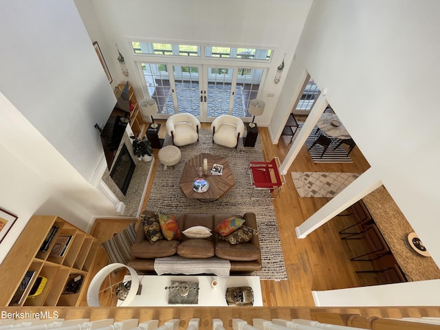 interior space with hardwood / wood-style flooring, a wealth of natural light, a fireplace, and a high ceiling