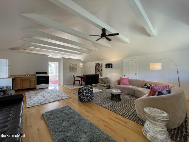 living room featuring light wood-type flooring, lofted ceiling with beams, ceiling fan, and sink