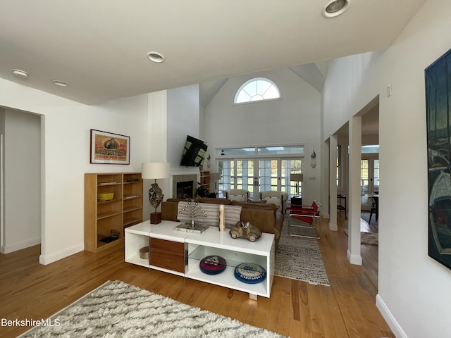 living room featuring french doors, vaulted ceiling, and hardwood / wood-style flooring