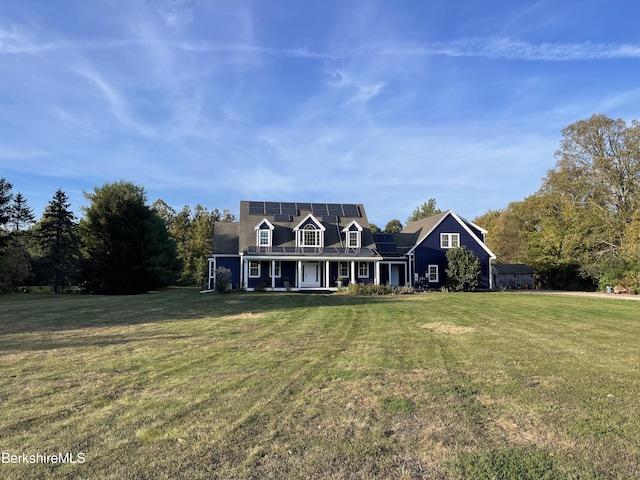 cape cod home featuring solar panels, a porch, and a front lawn