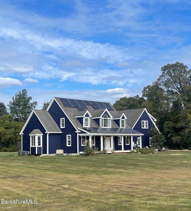 view of front of property featuring a front yard, solar panels, and a porch