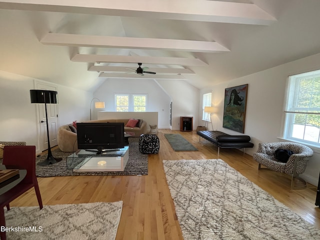 living room with hardwood / wood-style flooring, vaulted ceiling with beams, and a wealth of natural light