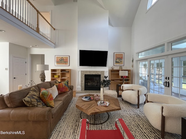 living room with french doors and a towering ceiling