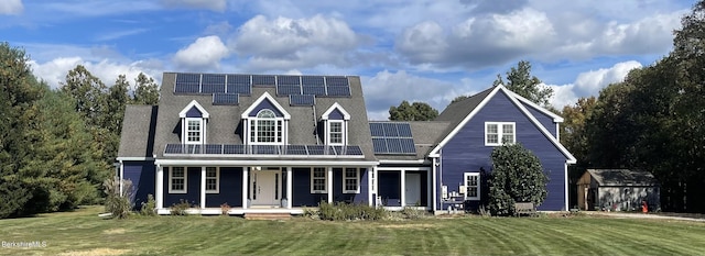 view of front facade with solar panels, a porch, a shed, and a front yard