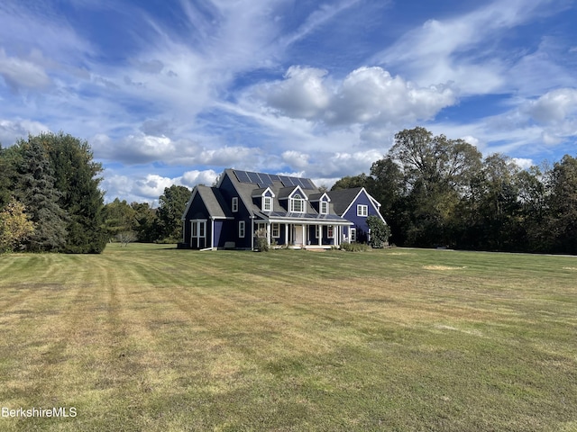 view of front of home with a front lawn and solar panels