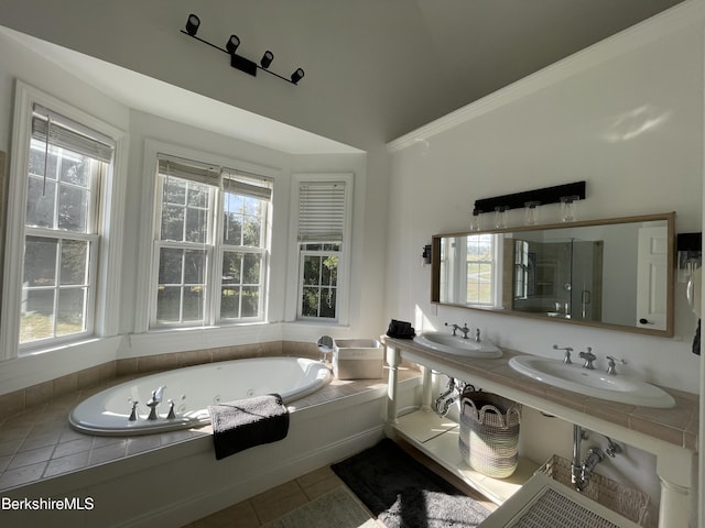 bathroom featuring tile patterned floors, dual sinks, a healthy amount of sunlight, and vaulted ceiling