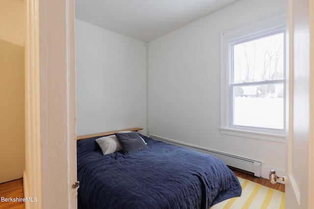 bedroom featuring light wood-type flooring and a baseboard radiator