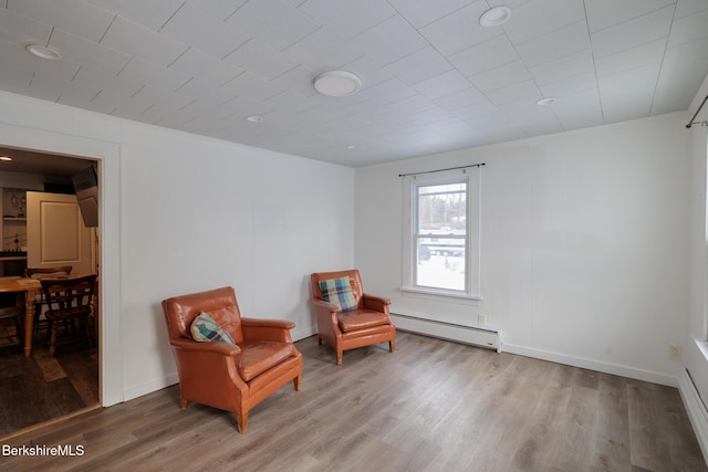 sitting room with hardwood / wood-style floors and a baseboard radiator