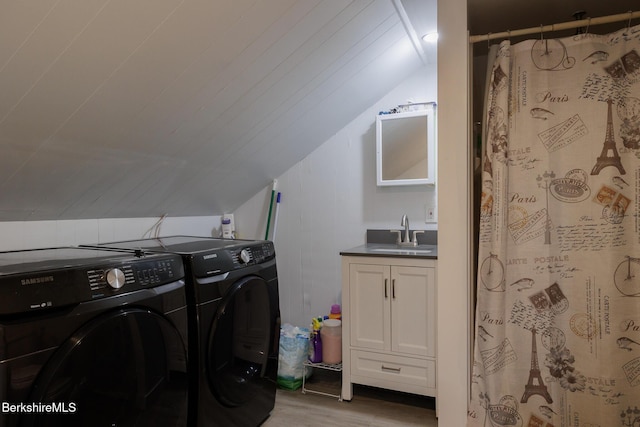 clothes washing area featuring washer and dryer, sink, and light hardwood / wood-style flooring