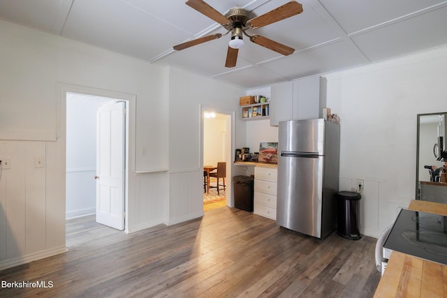 kitchen featuring butcher block counters, stainless steel fridge, white cabinets, and dark wood-type flooring