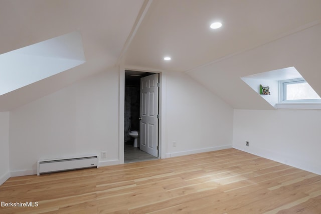 bonus room with vaulted ceiling, light hardwood / wood-style flooring, and a baseboard heating unit