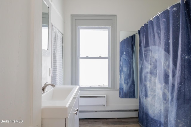 bathroom with vanity, a baseboard radiator, and hardwood / wood-style flooring