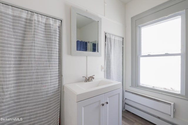 bathroom with vanity, a baseboard radiator, and wood-type flooring