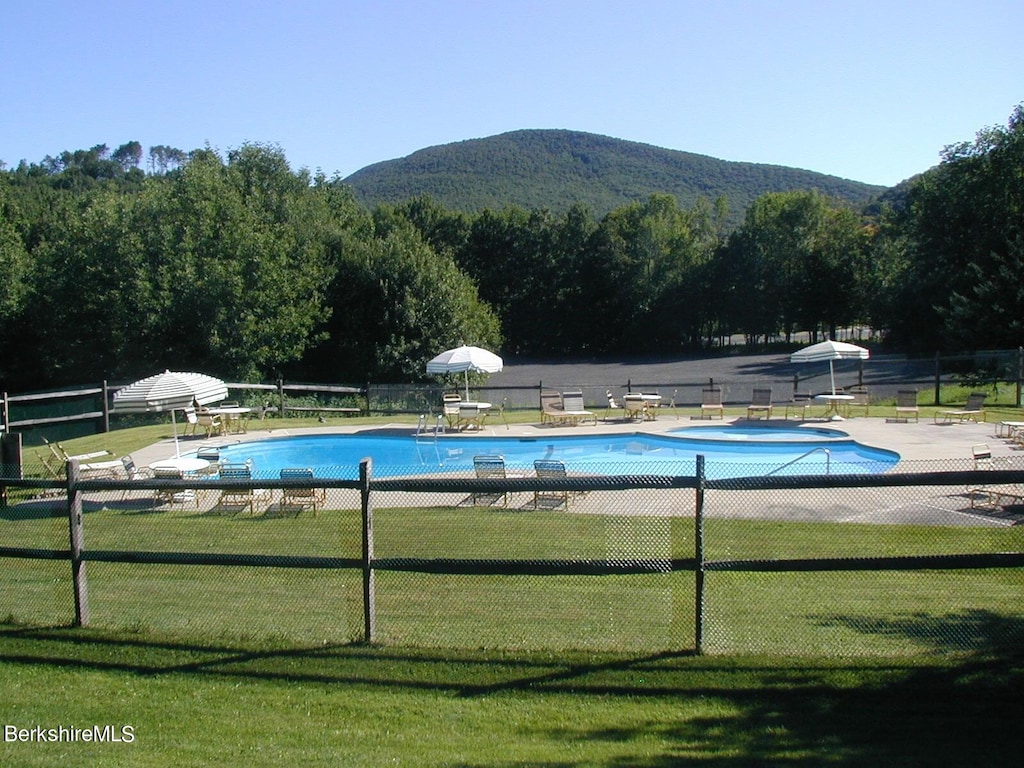 view of pool featuring a lawn, a mountain view, and a patio