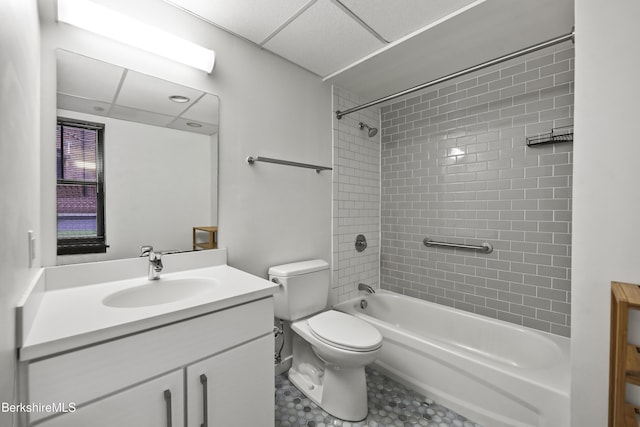 full bathroom featuring vanity, tiled shower / bath combo, toilet, and a drop ceiling