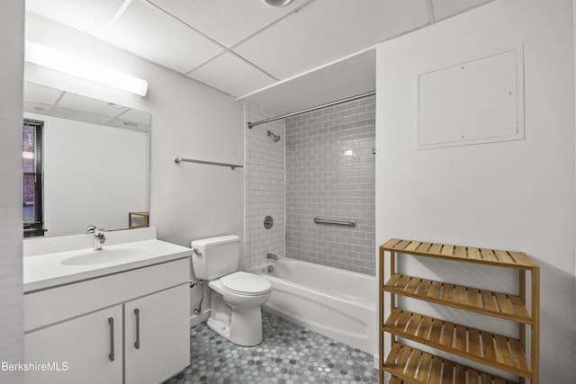 full bathroom with a paneled ceiling, vanity, toilet, and tiled shower / bath