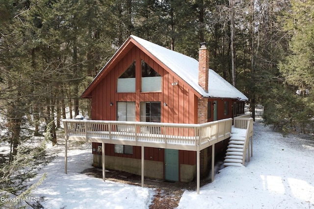 rustic home with a chimney and a wooden deck