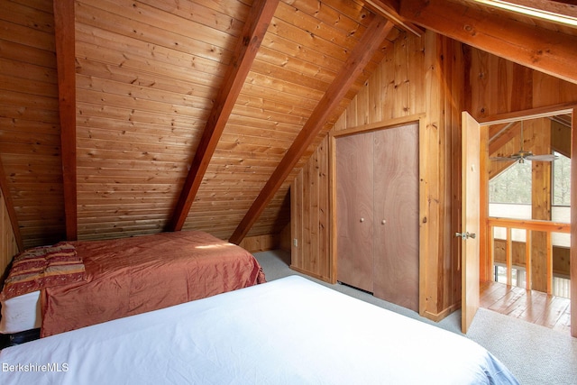 carpeted bedroom with lofted ceiling with beams, wooden ceiling, and wooden walls