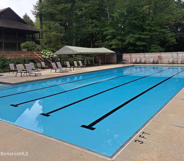 community pool featuring fence and a patio