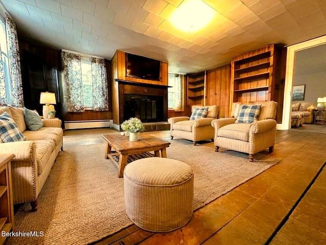 living room featuring a baseboard radiator and a glass covered fireplace
