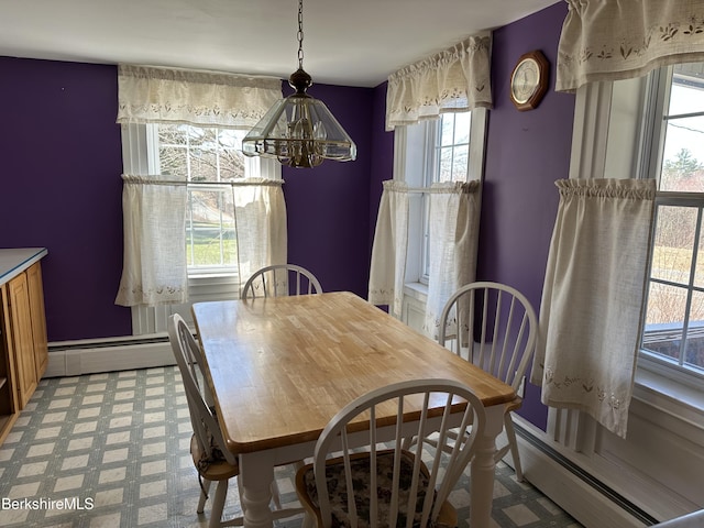 dining room featuring plenty of natural light, a baseboard radiator, and a chandelier