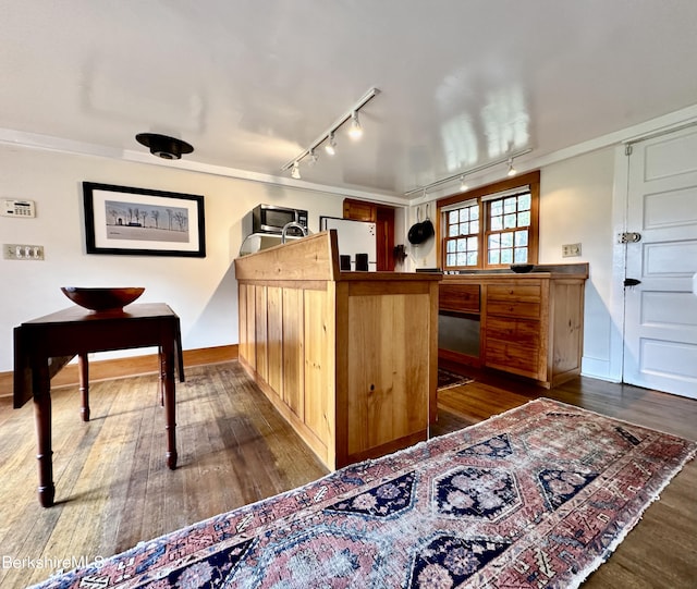 kitchen featuring kitchen peninsula, dark wood-type flooring, track lighting, and white refrigerator