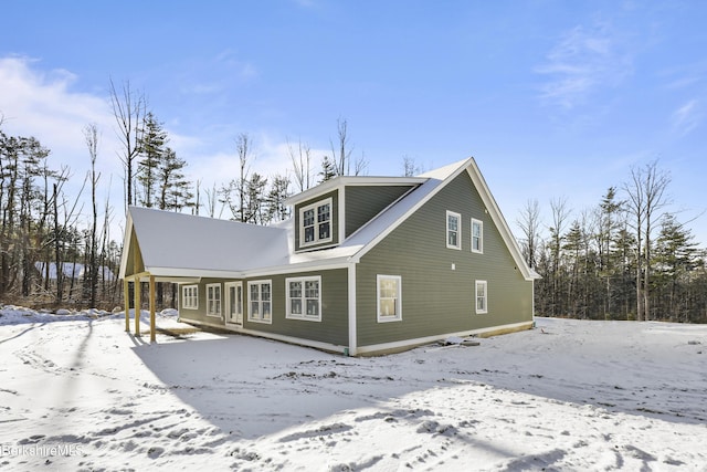 view of snow covered back of property