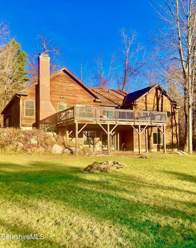 rear view of property featuring a yard and a deck