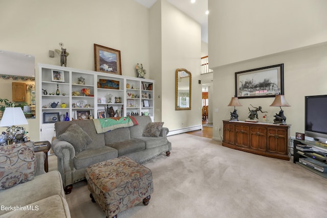 living room with a towering ceiling, light carpet, and a baseboard heating unit