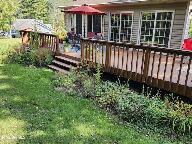 wooden terrace featuring a lawn