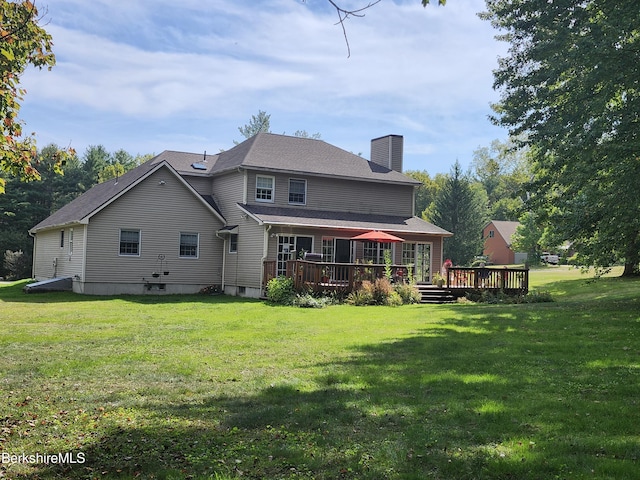 back of property with a wooden deck and a yard