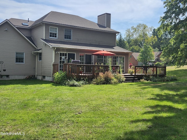 back of house with a lawn and a deck