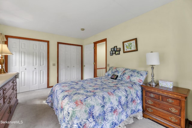 carpeted bedroom featuring multiple closets