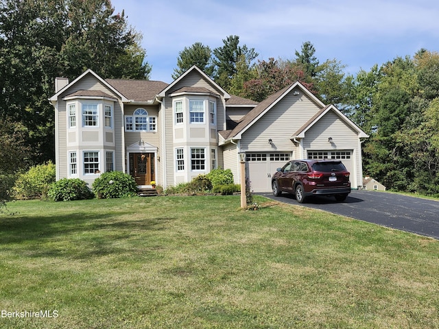 front facade featuring a garage and a front lawn