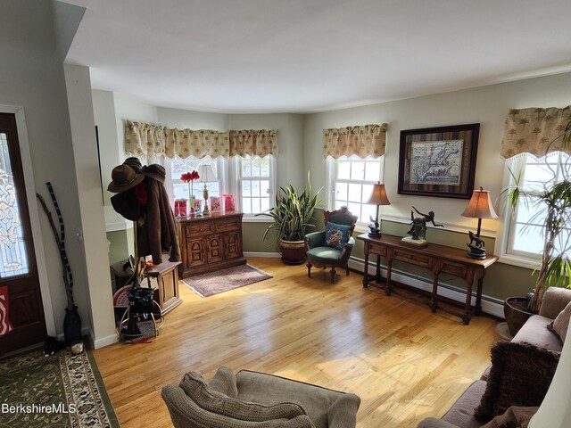 living room with light hardwood / wood-style flooring, a healthy amount of sunlight, and a baseboard radiator