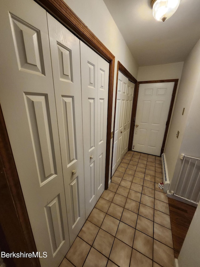 hallway with light tile patterned floors and a baseboard radiator