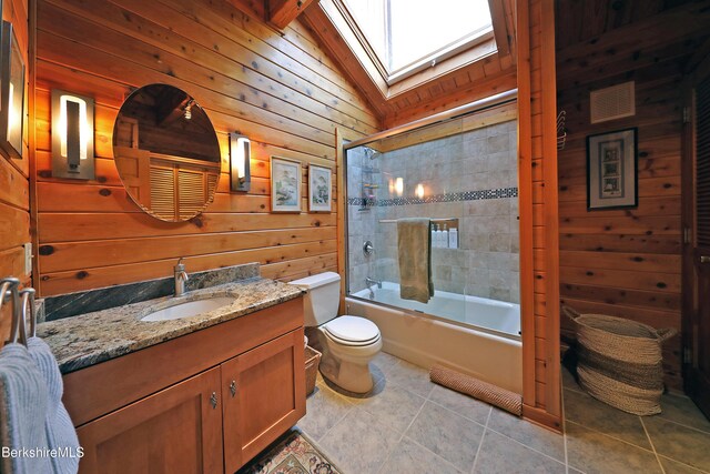 55 Mallard Dr, Becket, MA 01223 - full bathroom featuring wood walls, a skylight, vanity, tile patterned floors, and combined bath / shower with glass door
