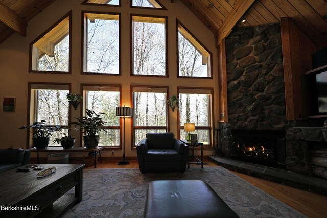 55 Mallard Dr, Becket, MA 01223 - living room featuring a wood ceiling with exposed beams, a fireplace, wood finished floors, and high vaulted ceiling